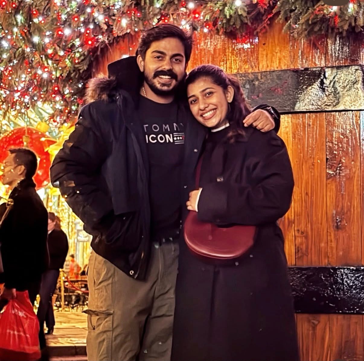 The couple beneath festive lights