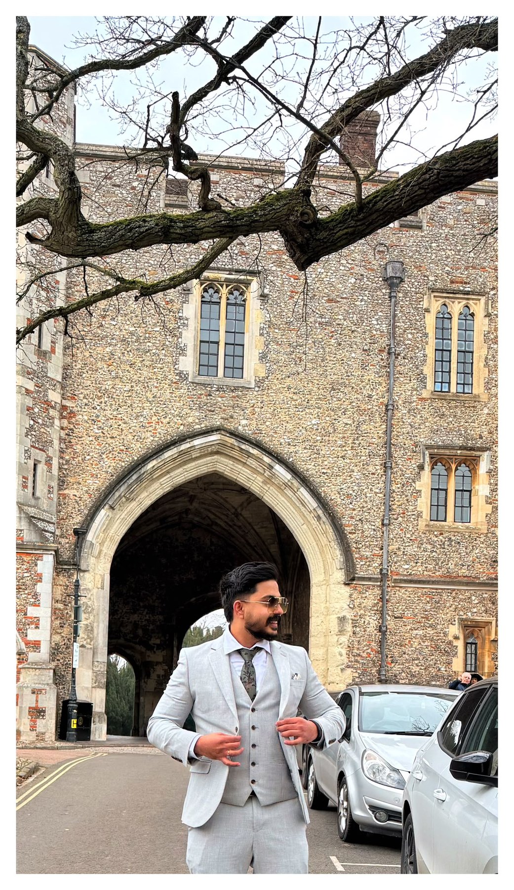 Aghil in a suit beneath a stone arch